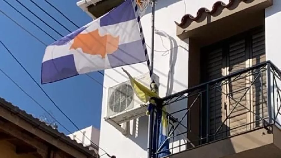 Μπαλκόνι με γαλανόλευκη - γαλαζοκίτρινη σημαία στην Οδού/ανάρτηση Ν. Πετεβίνου